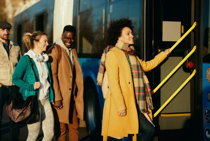 Commuters boarding city bus at station