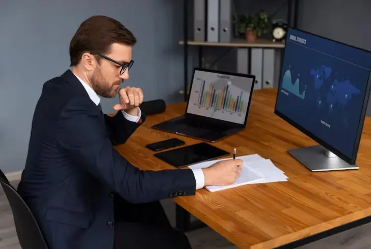 A person analysing a graph on a laptop screen