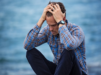 man-in-blue-and-brown-plaid-dress-shirt-touching-his-hair